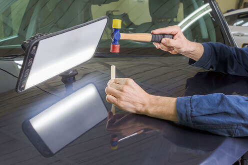 Professional mechanic removes dents on the car body in frisco tx